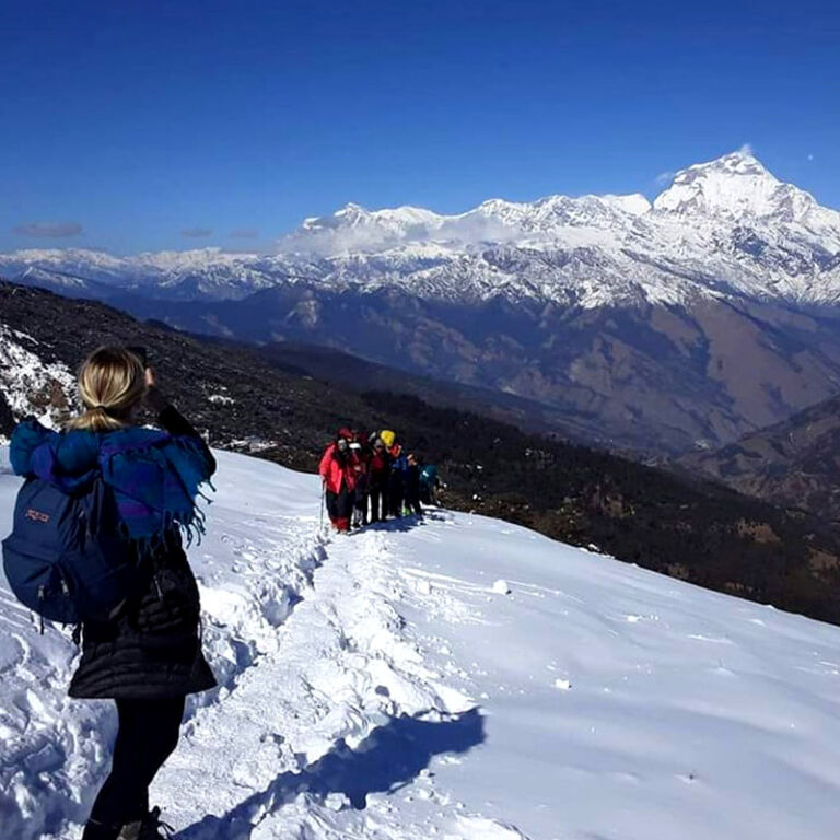 A group of people hiking up a snowy mountain, enjoying the breathtaking winter scenery.